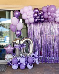 balloons and streamers decorate the entrance to a birthday party