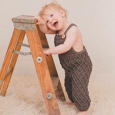 a small child on a ladder with his mouth open