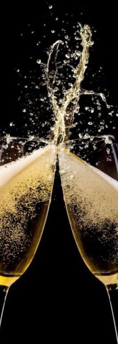 two glasses of champagne are being filled with water and bubbles on a black background photo