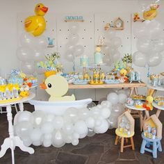 a baby shower party with rubber ducky in the bathtub, balloons and decorations