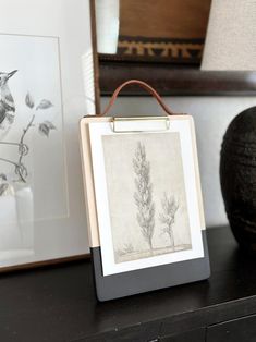 a black and white photo sitting on top of a wooden table next to a lamp