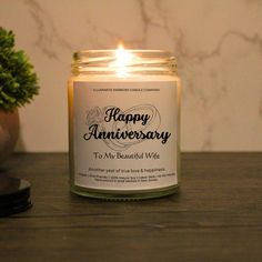 a candle sitting on top of a table next to a potted plant