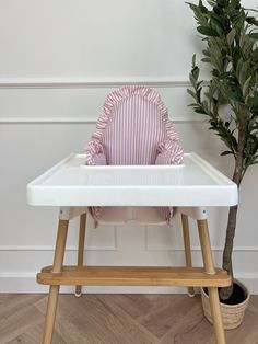 a baby's high chair next to a potted plant