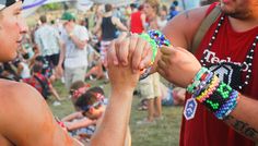 two men are holding beads in their hands at an outdoor event while others look on