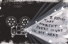 a black and white photo with words written on the wall next to a movie projector