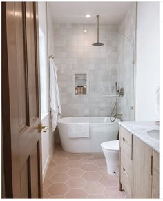 a bathroom with a tub, toilet and sink