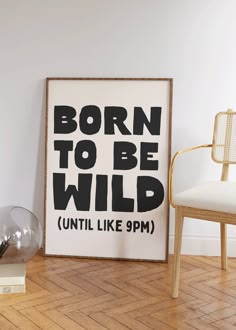 a black and white poster with the words born to be wild on it next to a chair