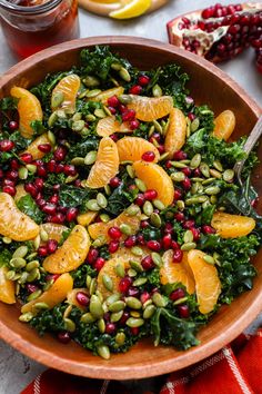 a wooden bowl filled with oranges and greens