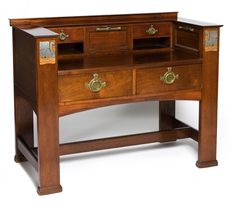 an antique wooden desk with drawers and gold trimmings on the top, against a white background