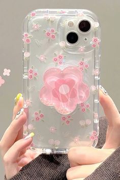 a woman holding up a clear case with pink flowers on the front and back of it