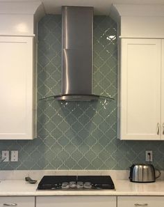 a stove top oven sitting inside of a kitchen next to white cabinets and cupboards