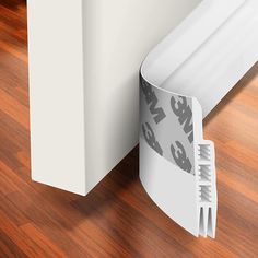 an image of the corner of a room with wood flooring and white trimming