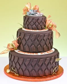 a three tiered chocolate cake with flowers on top