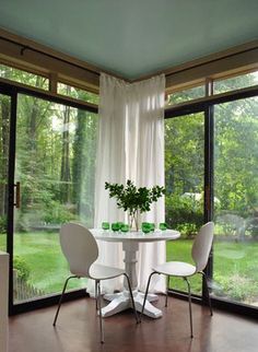 a dining room table with two white chairs