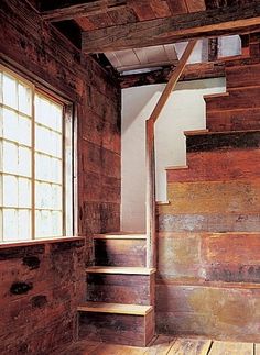 an empty room with wooden stairs and windows