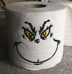 a close up of a roll of toilet paper with a face drawn on the front