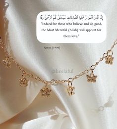 a gold necklace with four charms hanging from it's sides and an arabic quote