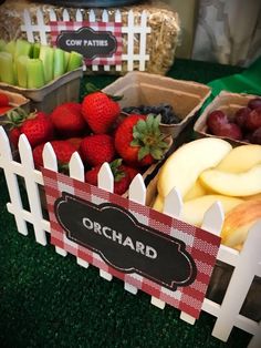 there are many different types of fruit in baskets on the table with name tags attached to them