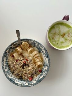 a bowl of oatmeal next to a cup of green tea