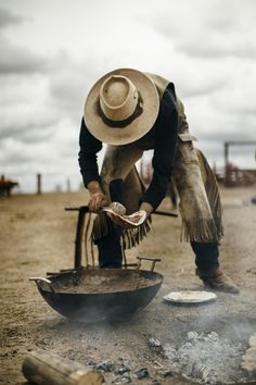 a man cooking food on top of a frying pan