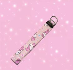 a hello kitty keychain on a pink background