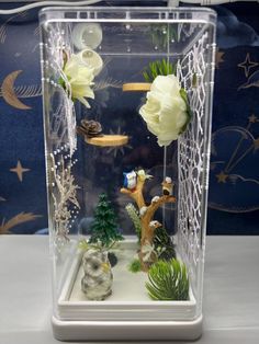 a clear case with flowers and plants in it