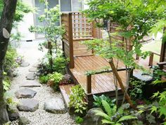 an aerial view of a wooden deck surrounded by greenery and trees in the background