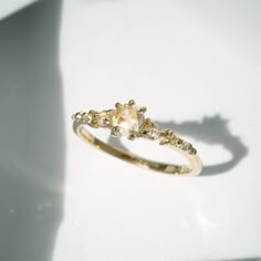 a yellow gold ring with two diamonds on it's sides and a shadow behind it