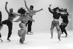 a group of people jumping in the air with their arms up and legs spread out