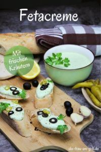 a wooden cutting board topped with bread and olives