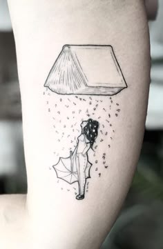 a woman with an umbrella under a book tattoo on her arm and the light coming from it