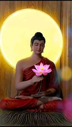 a buddha statue holding a pink flower in front of the sun