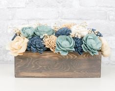 a wooden box filled with flowers on top of a table