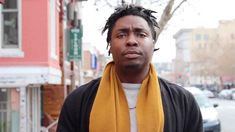 a man with dreadlocks standing on the street