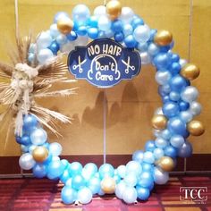 blue and gold balloon arch with no hair don't care sign