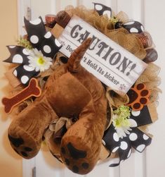 a stuffed animal laying on top of a wreath with a sign that says gayton