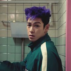 a young man with purple hair in a bathroom