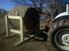 a tractor pulling a hay bale behind it