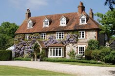 a large brick house with purple flowers on it