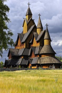 an old wooden church in the middle of a field