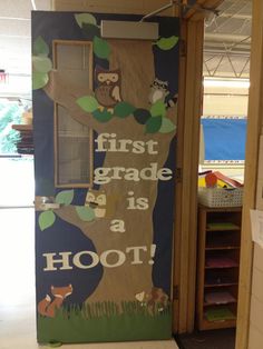 a classroom door decorated with an image of a tree and the words first grade is a hoot