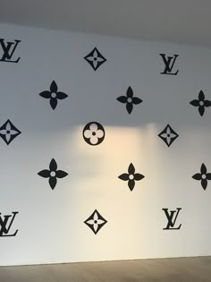 the wall has many louis vuitton decals on it and is painted black