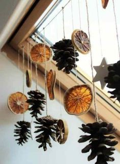 pine cones are hanging from the ceiling in front of a window with star decorations on it