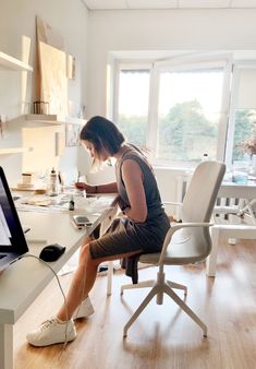 a woman sitting at a desk working on her computer