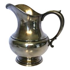 a shiny silver pitcher is shown on a white background