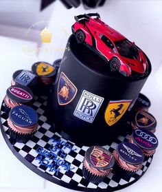 a cupcake with cars on it sitting on top of a cake plate