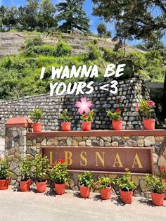 a sign that says i wanna to be yours - 3 in front of some potted plants