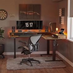 a computer desk sitting in the middle of a living room next to a chair and window