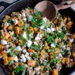 a skillet filled with vegetables and feta cheese