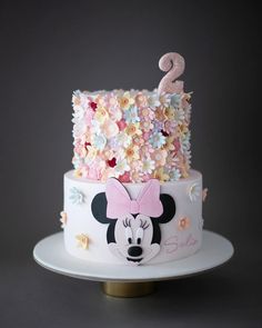 a birthday cake decorated with flowers and a minnie mouse number 2 on it's side